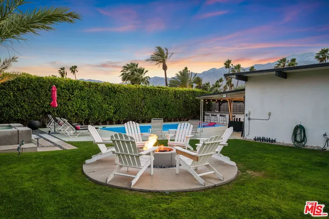 a view of a house with backyard sitting area and furniture