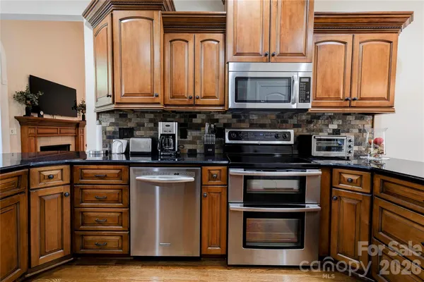 a kitchen with stainless steel appliances granite countertop a stove and a microwave