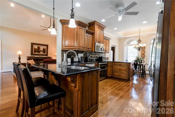 a kitchen with granite countertop a sink a counter top space and stainless steel appliances