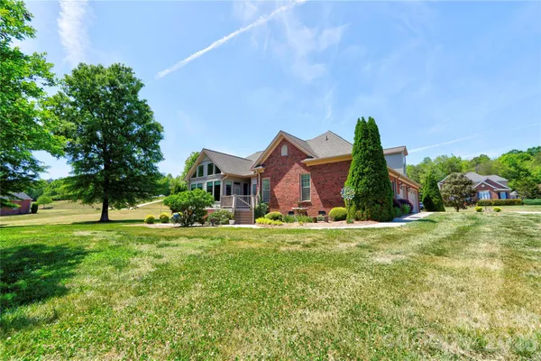 a front view of a house with a garden and trees