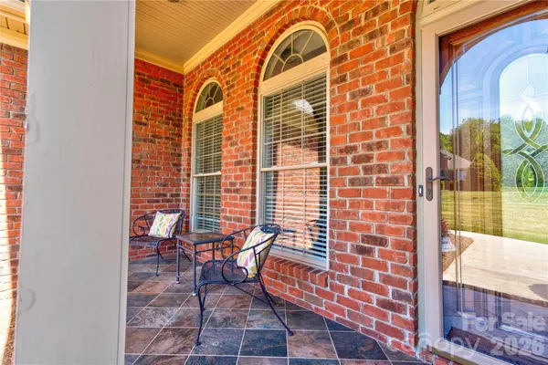 a view of a brick wall with a bench in patio