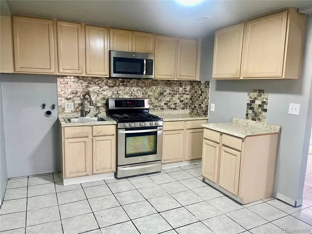 a kitchen with white cabinets appliances and a sink
