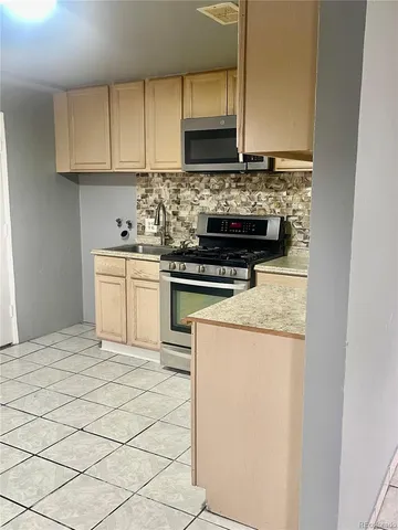 a kitchen with a stove top oven and cabinets