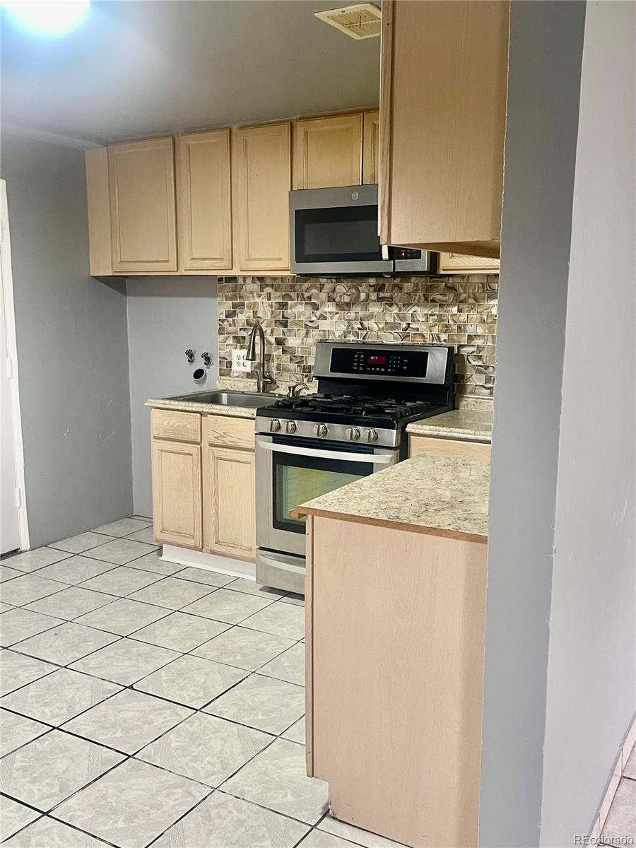 4332 West Nevada Place Denver, CO 80219 - Photo 7 of 14 a kitchen with a stove top oven and cabinets