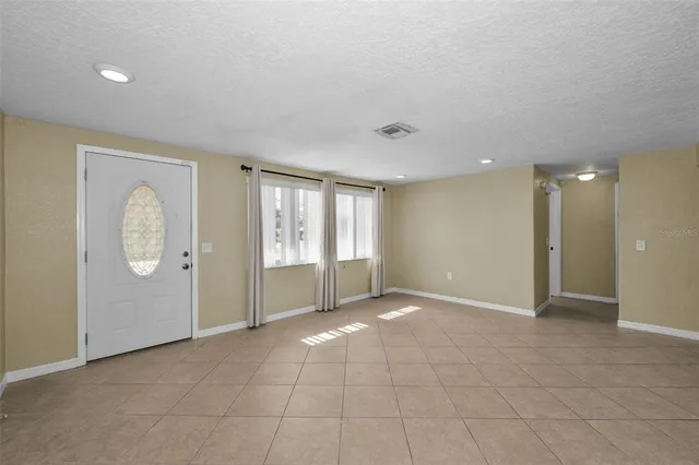 a view of an empty room with window and cabinet