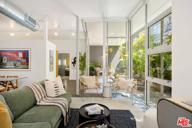 a living room with furniture a large window and a flat screen tv