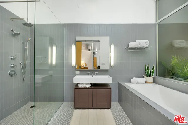 a bathroom with a double vanity sink a mirror and a bathtub