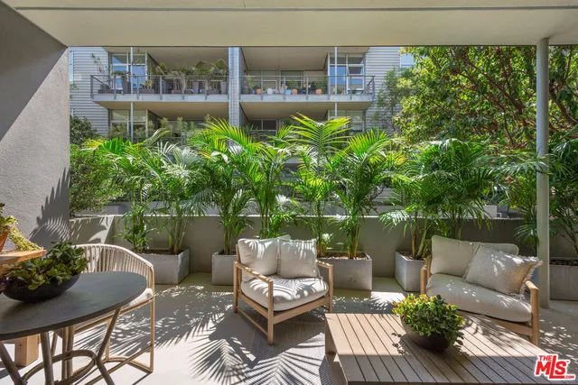 a view of a patio with couches table and chairs and potted plants