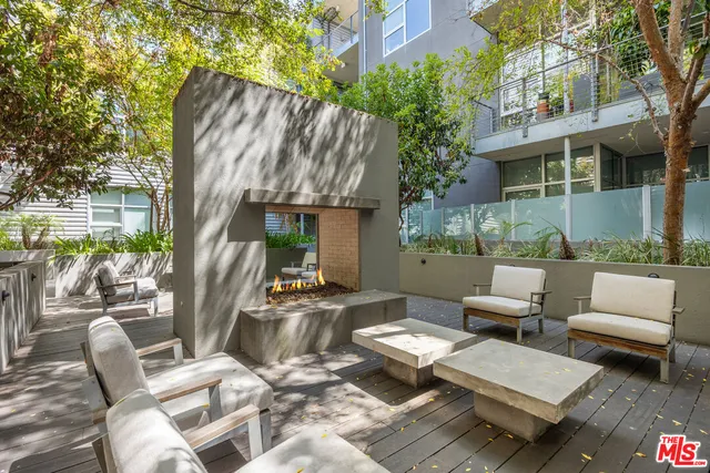a view of a patio with couches table and chairs and potted plants