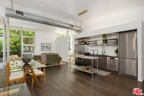 a kitchen with stainless steel appliances a stove a refrigerator and wooden floor