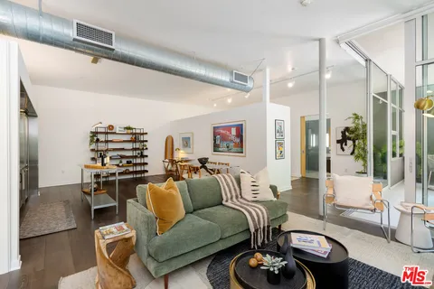 a living room with furniture a rug and white walls