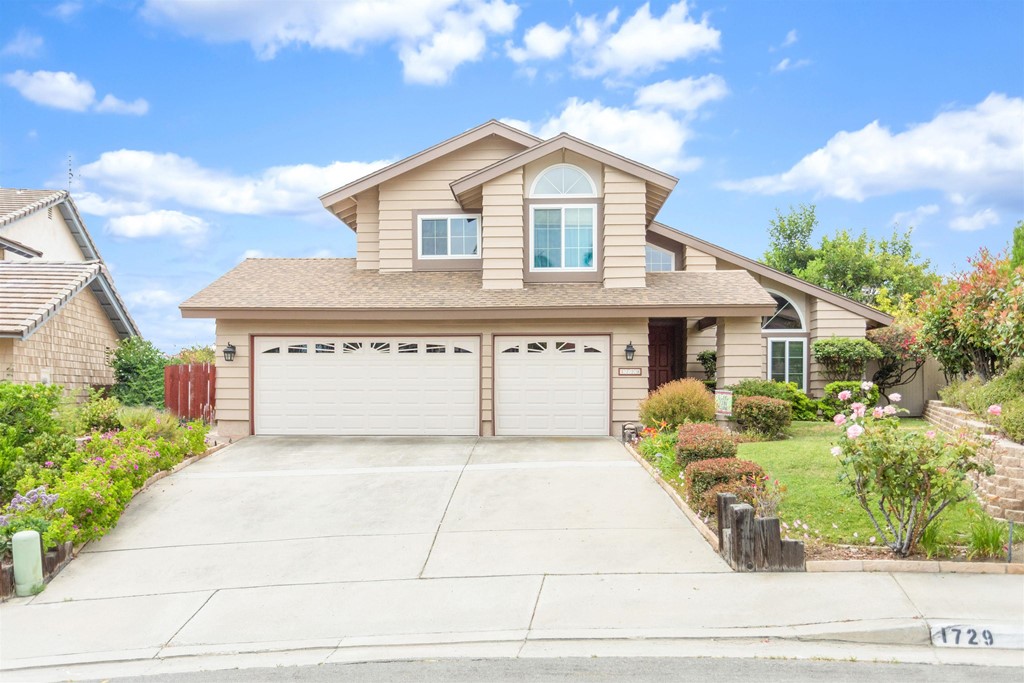 a front view of a house with a garden and plants
