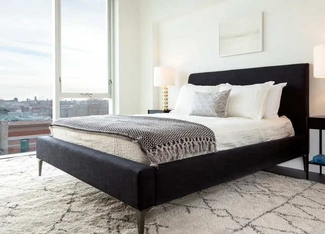 a bedroom with a bed lamp and window