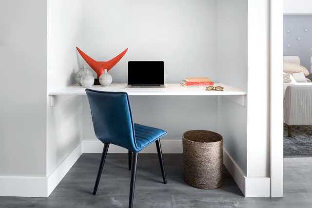 a room with a chair and potted plant