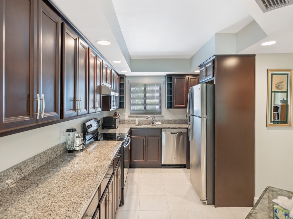 1155 Reef Road, Unit B7 Vero Beach, FL 32963 - Photo 12 of 31 a kitchen with stainless steel appliances granite countertop a refrigerator and a sink