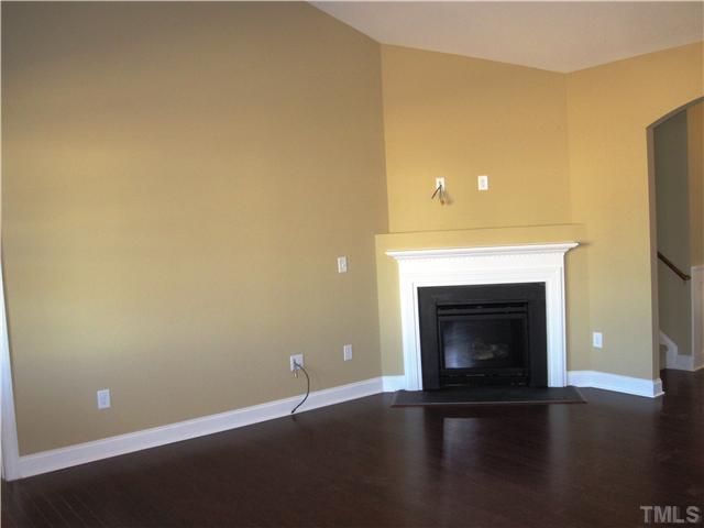 7639 Birchmoor Way, Unit LT91 Raleigh, NC 27616 - Photo 7 of 15 a view of an empty room with wooden floor and a fireplace