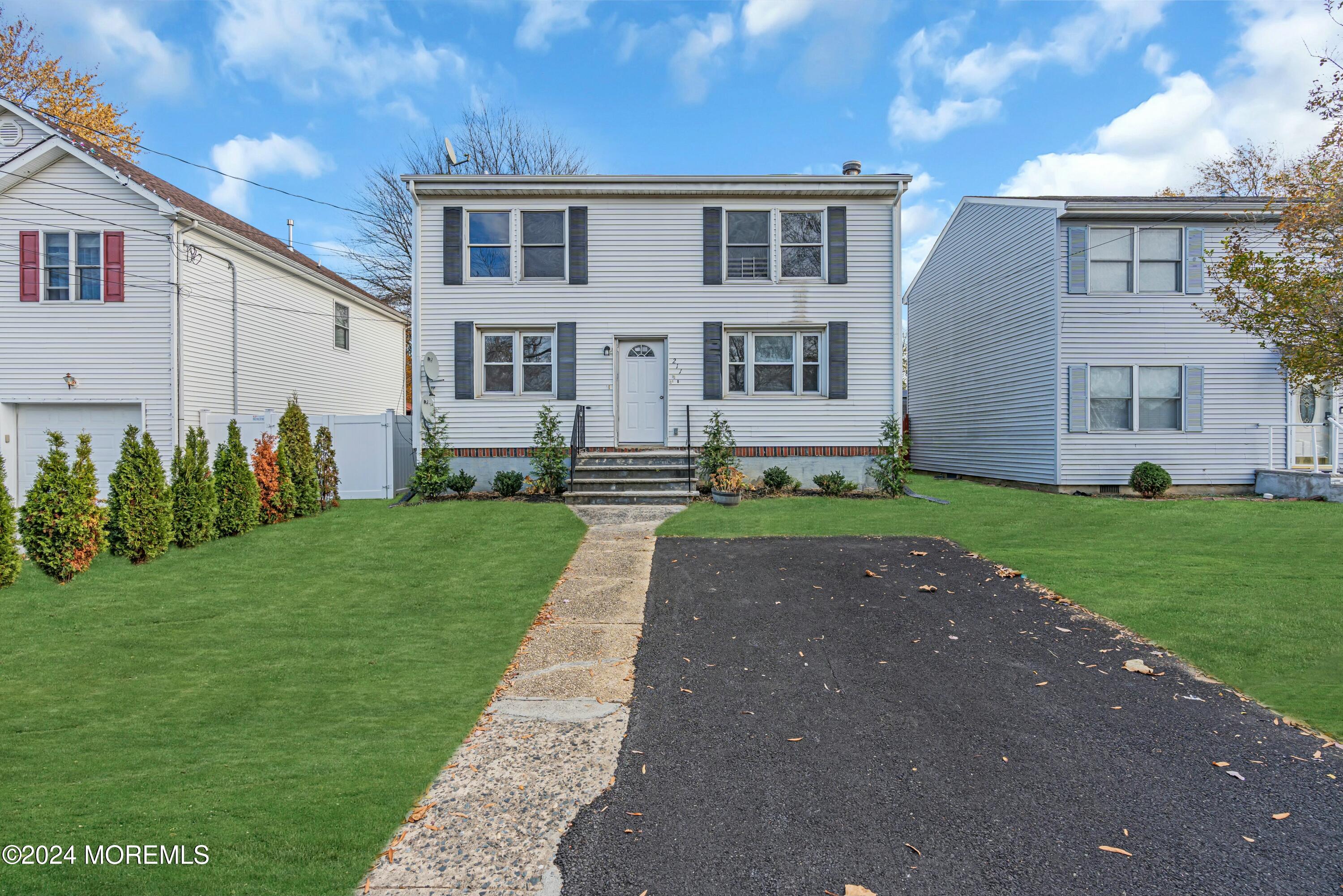 211 Delaware Avenue, Unit 2 Cliffwood, NJ 07721 - Photo 4 of 16 a front view of a house with a garden and yard
