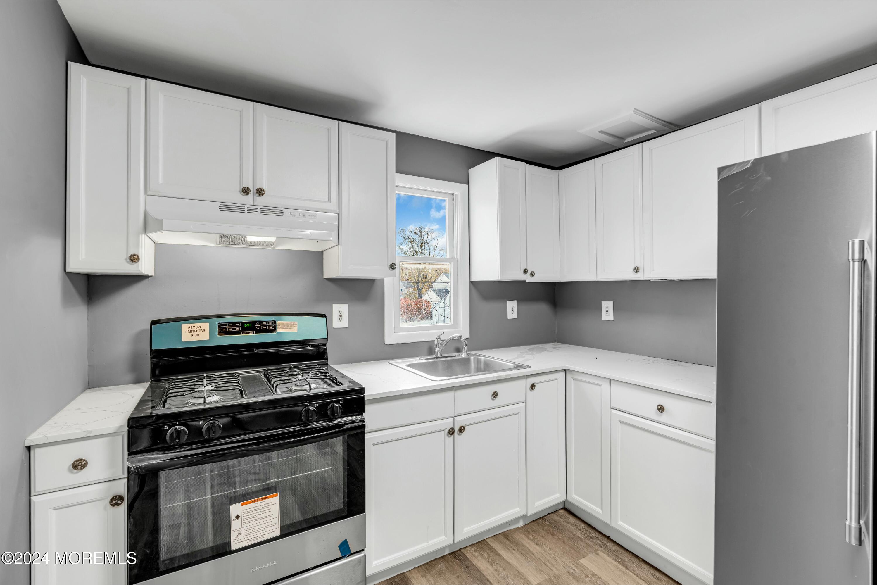 211 Delaware Avenue, Unit 2 Cliffwood, NJ 07721 - Photo 10 of 16 a kitchen with cabinets appliances and a sink