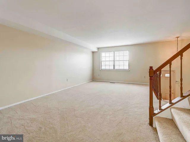 an empty room with windows & hardwood