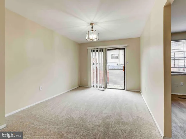 an empty room with windows and ceiling fan