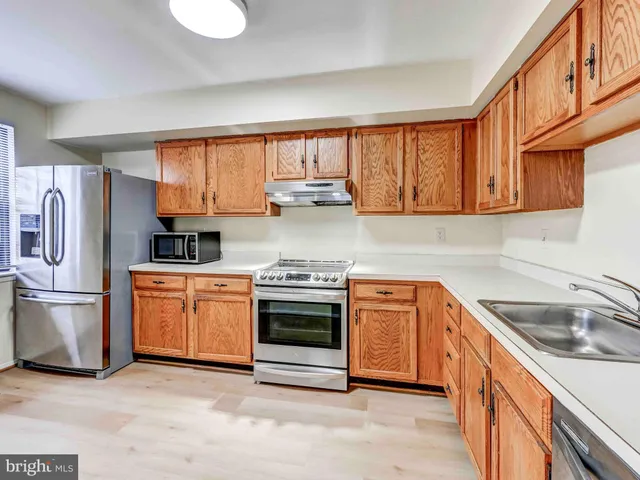 a kitchen with a stove a microwave and wooden floor