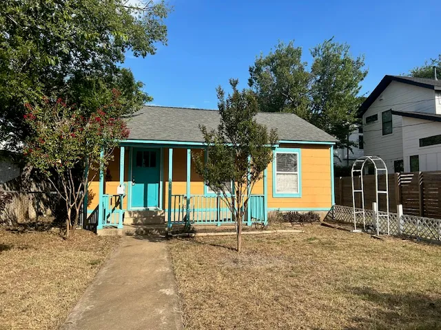 a front view of a house with glass windows and yard