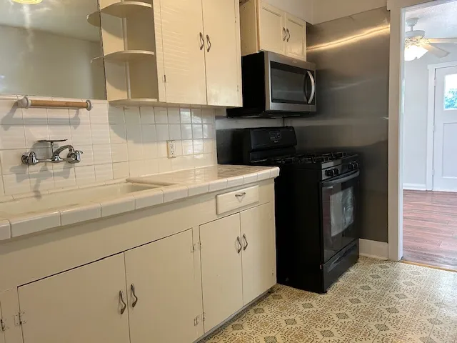 a kitchen with a sink stove and microwave