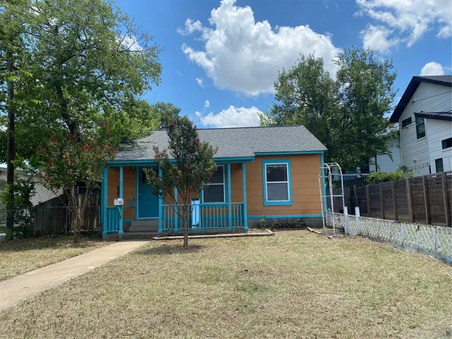 a view of house with backyard and trees