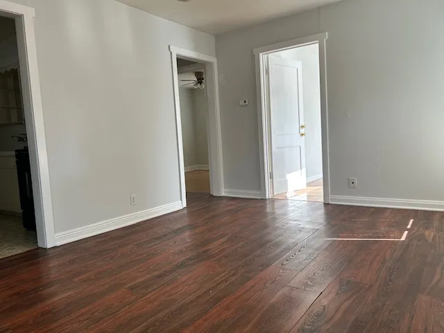 an empty room with wooden floor and closet area
