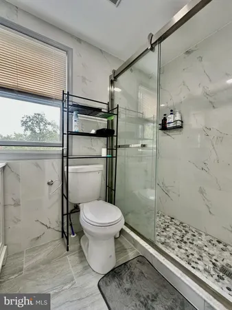 a bathroom with a toilet and a shower