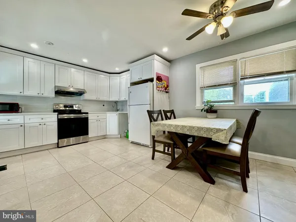 a kitchen with a table chairs microwave and cabinets