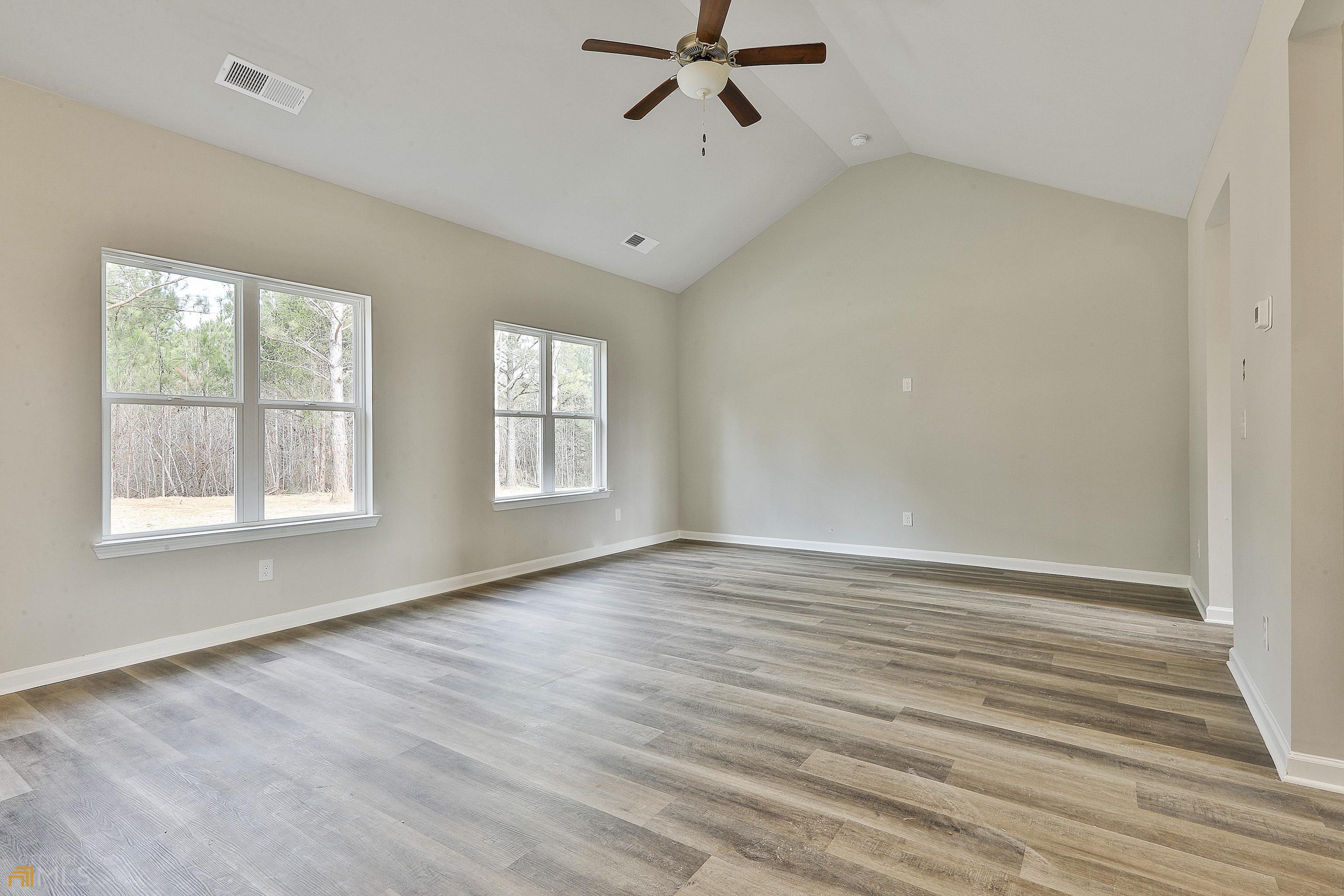 3575 Strickland Town Road Luthersville, GA 30251 - Photo 14 of 29 an empty room with wooden floor fan and windows