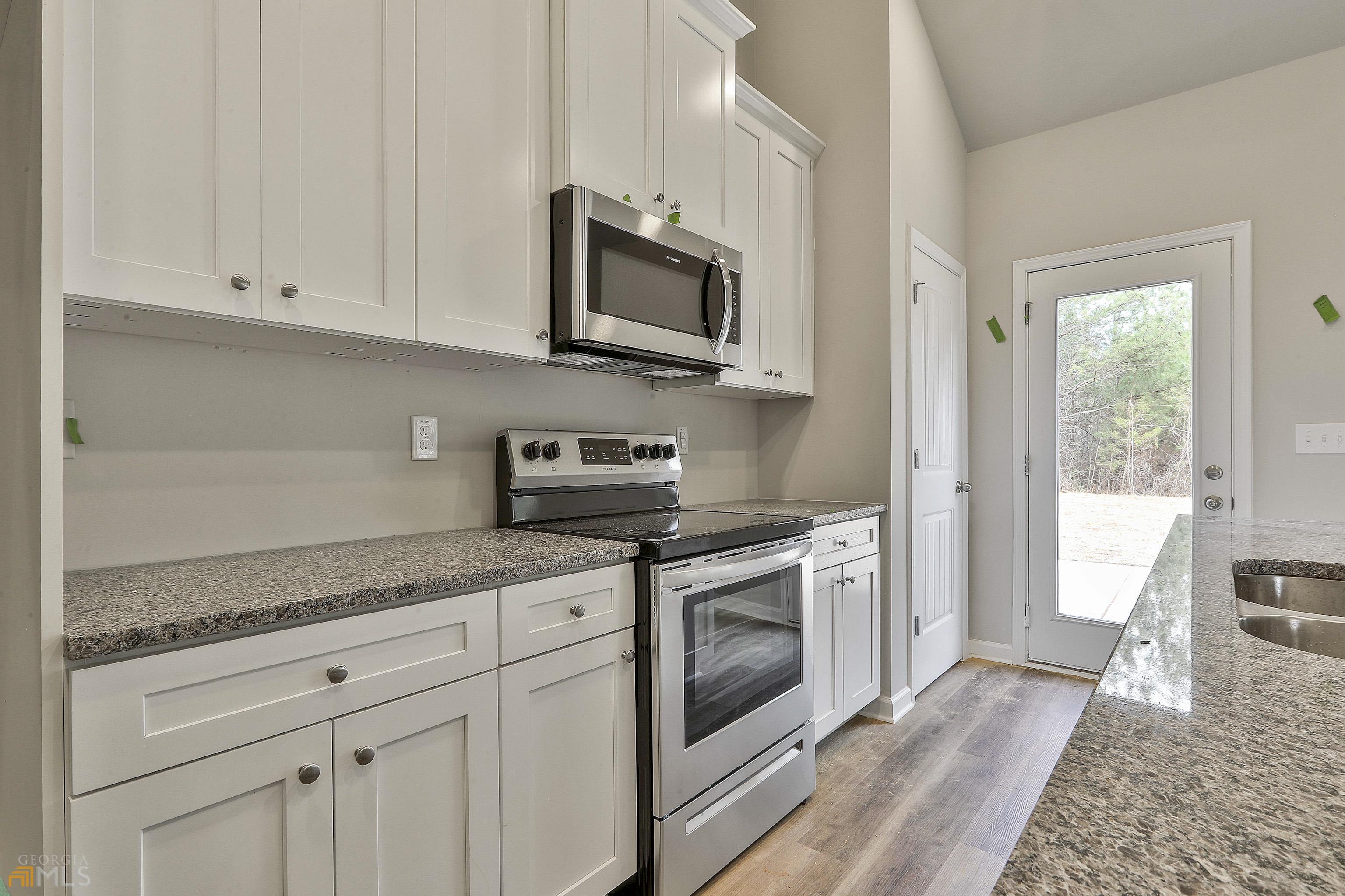 3575 Strickland Town Road Luthersville, GA 30251 - Photo 23 of 29 a kitchen with stainless steel appliances granite countertop a stove a sink and a microwave
