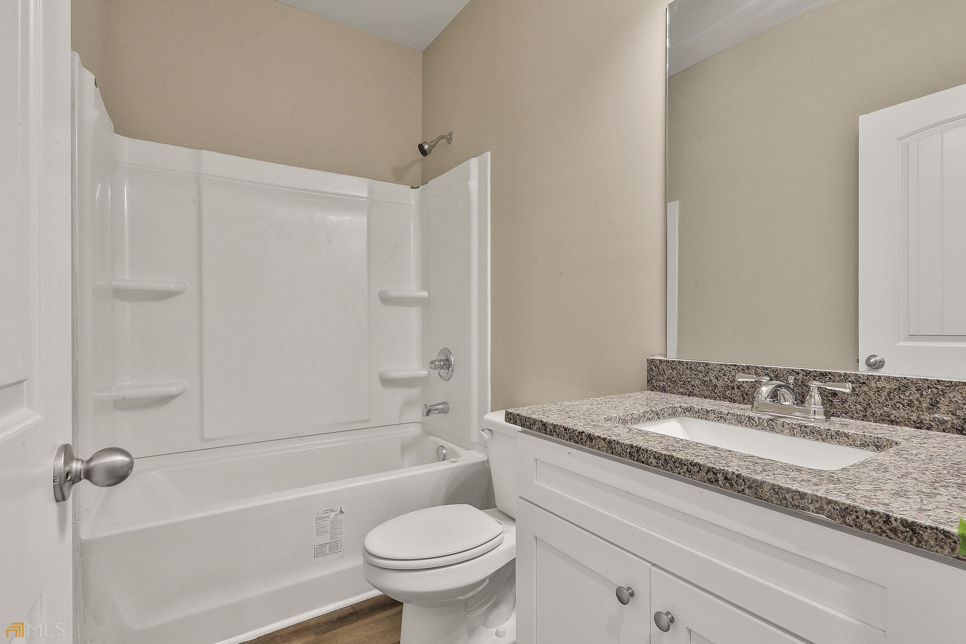 3575 Strickland Town Road Luthersville, GA 30251 - Photo 26 of 29 a bathroom with a granite countertop sink a toilet and shower