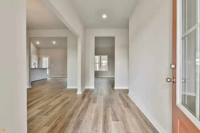 a view of a hallway with wooden floor and staircase