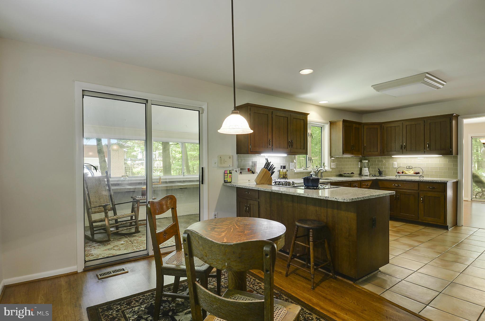 21013 Sunnyacres Road Gaithersburg, MD 20882 - Photo 12 of 30 a kitchen with kitchen island granite countertop a sink and a refrigerator