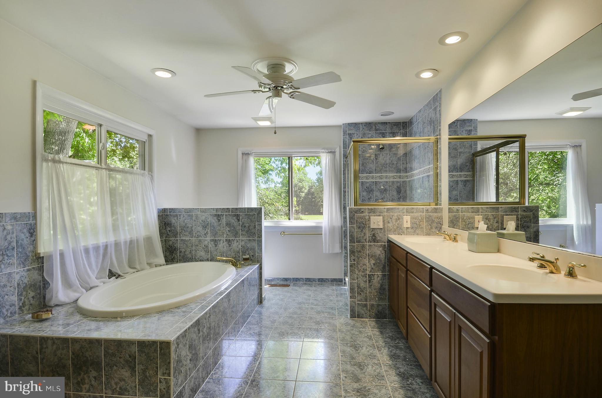 21013 Sunnyacres Road Gaithersburg, MD 20882 - Photo 24 of 30 a bathroom with a granite countertop sink a toilet a mirror and a tub
