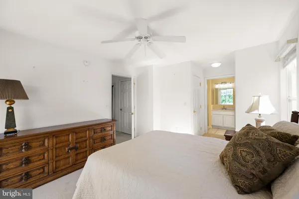 a bedroom with a bed a dresser and potted plants on the dresser