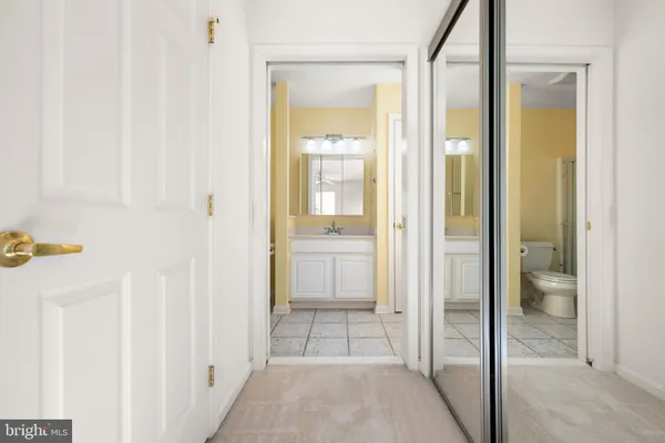 a view of a bathroom from a hallway with wooden floor