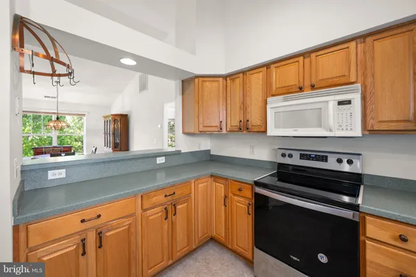 a kitchen with granite countertop a stove sink and cabinets