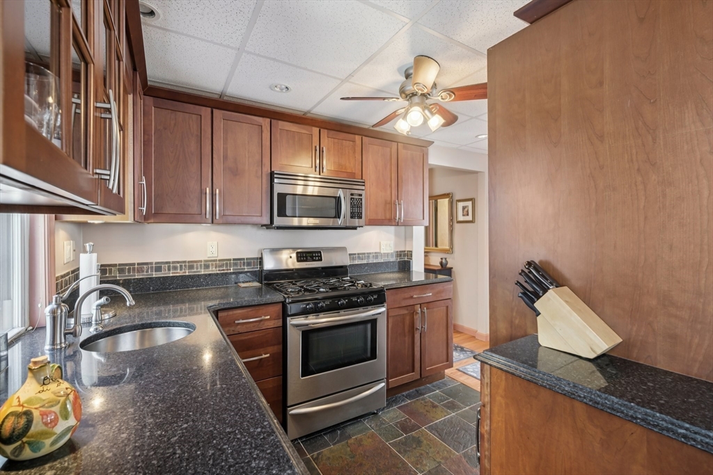 39-41 Kinsman Street Everett, MA 02149 - Photo 7 of 37 a kitchen with granite countertop stainless steel appliances a stove a sink and a microwave