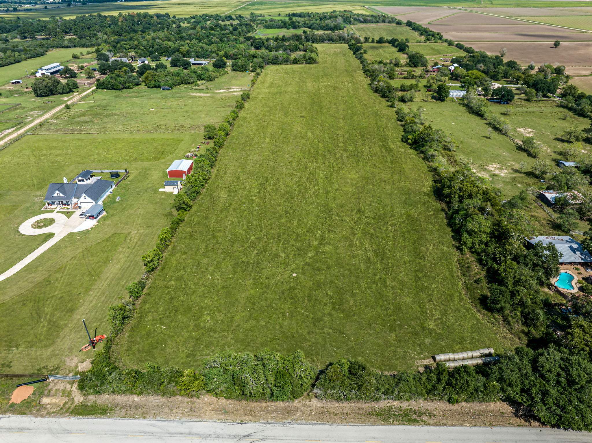 37280 Clapp Road Brookshire, TX 77423 - Photo 2 of 34 A vast expanse of green pastureland stretches out under an open sky.