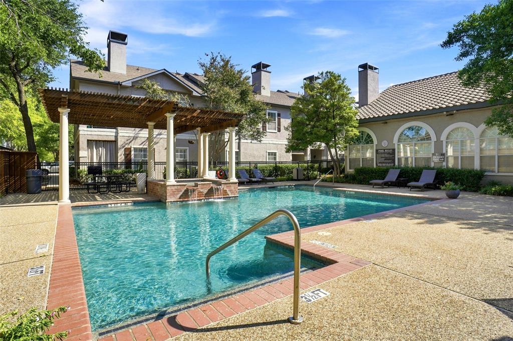 2601 Preston Road, Unit 4103 Plano, TX 75093 - Photo 14 of 16 Outdoor swimming pool with integrated spa and water feature, surrounded by exposed aggregate concrete decking and brick coping