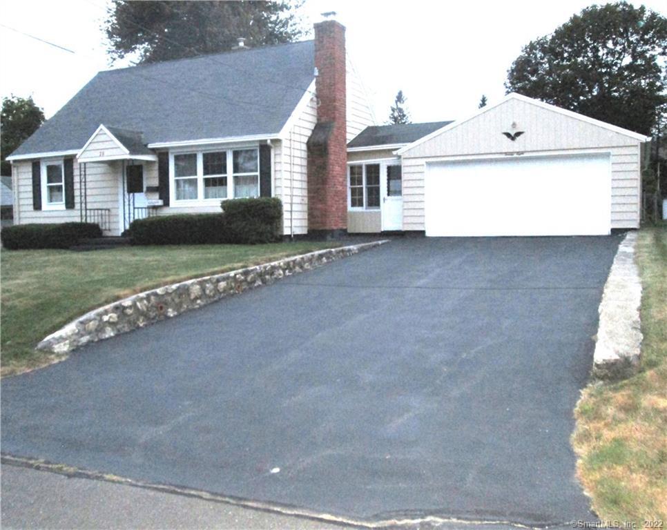 a view of a white house next to a yard with big trees
