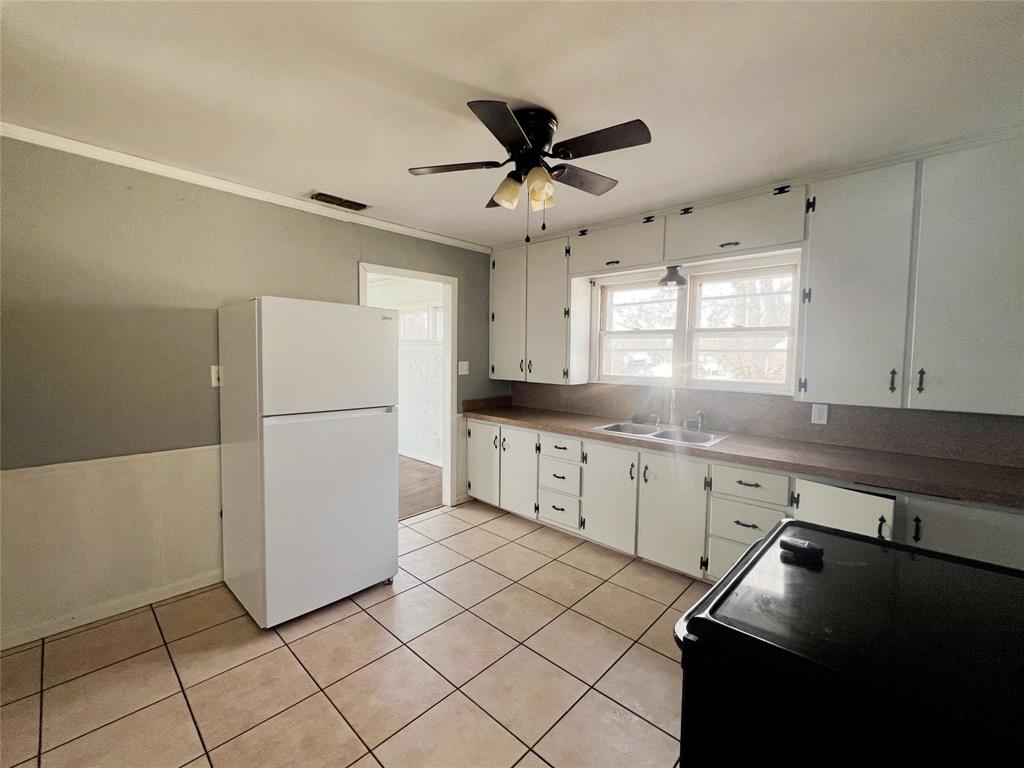 402 South Red River Street Henrietta, TX 76365 - Photo 13 of 20 a kitchen with a refrigerator a sink dishwasher and cabinets