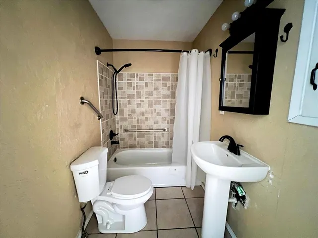 a bathroom with a toilet sink and shower