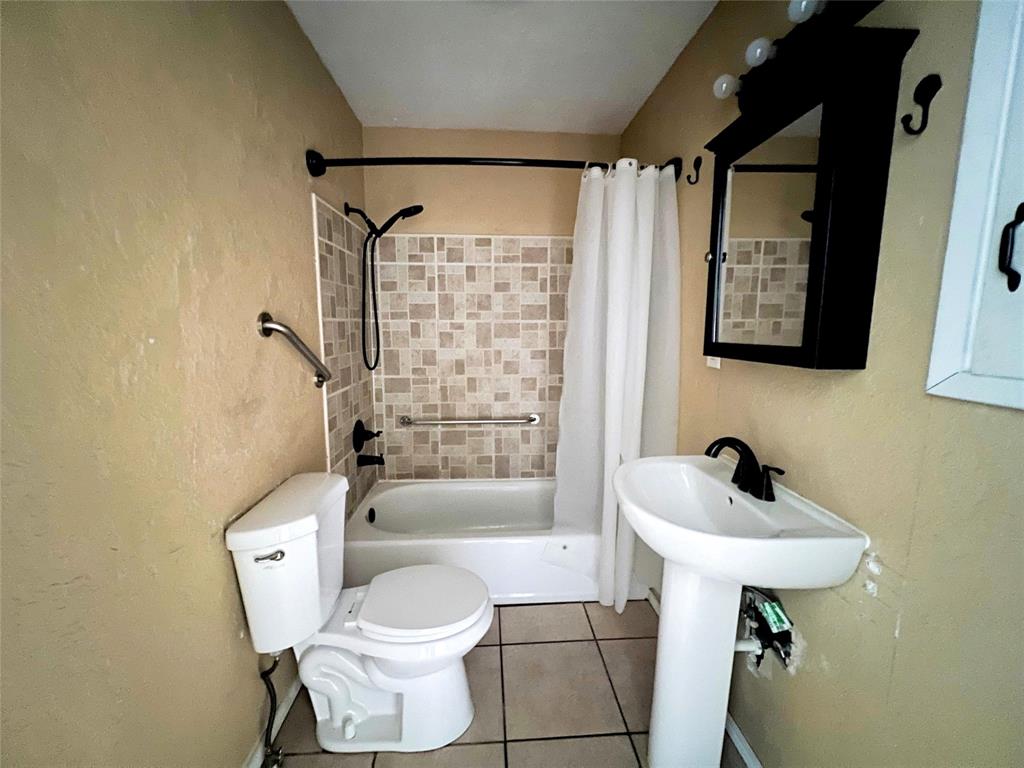 402 South Red River Street Henrietta, TX 76365 - Photo 15 of 20 a bathroom with a toilet sink and shower
