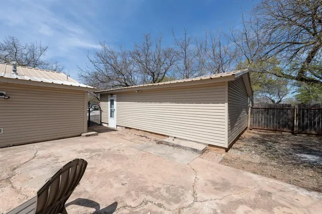 a view of backyard with cabin and wooden fencing