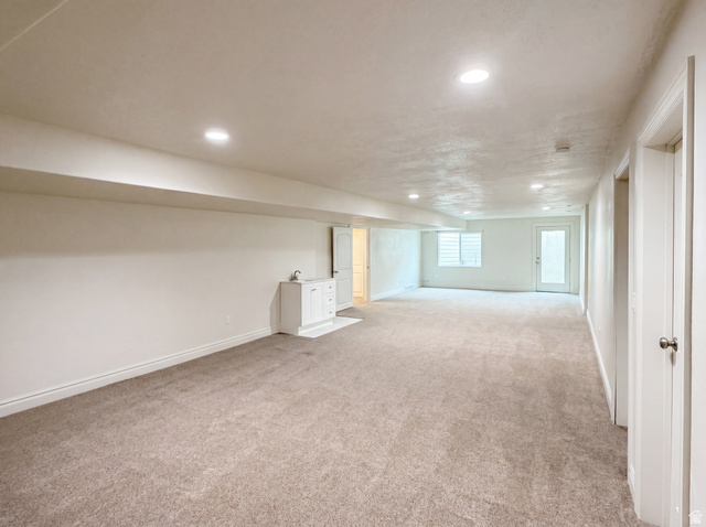 1251 North 2525 West Clinton, UT 84015 - Photo 23 of 30 Spacious carpeted room featuring recessed lighting, a built-in wet bar with cabinet storage, a window with horizontal blinds, and a glass-paneled exterior door
