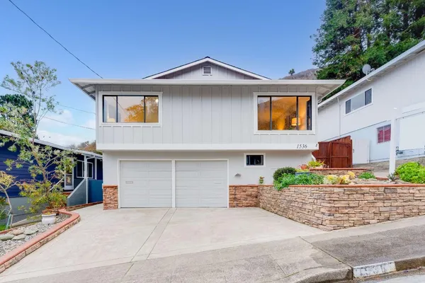 a front view of a house with a yard and garage